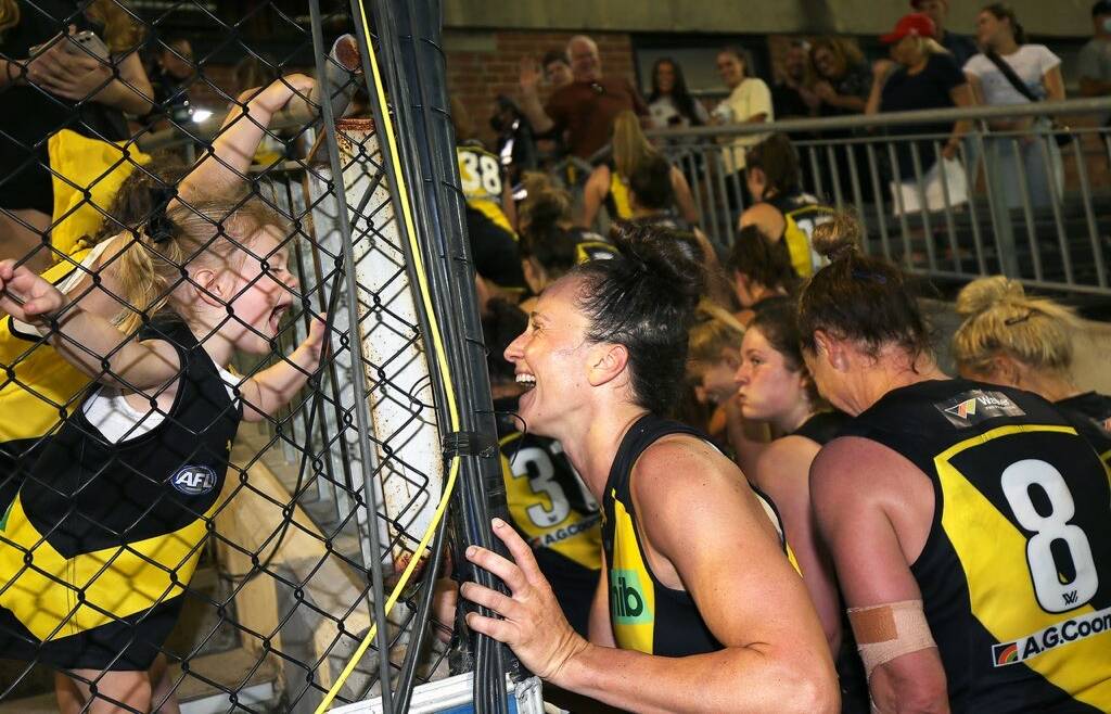 One of Ludbey's favourites ... Richmond AFLW player Harriet Cordner responds to a young fan giving Tiger roar at Punt Rd